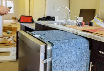 Handyman near tools equipment repair dishwasher machine in the kitchen